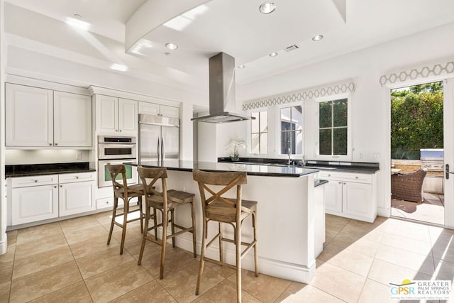 kitchen with white cabinetry, appliances with stainless steel finishes, island range hood, and a kitchen island