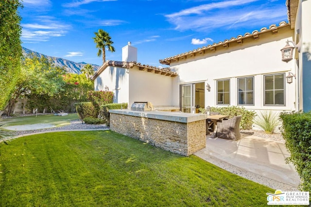 view of yard featuring a mountain view, an outdoor bar, area for grilling, and a patio