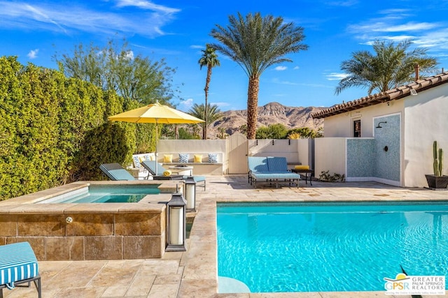 view of pool with a patio area, a mountain view, and an in ground hot tub