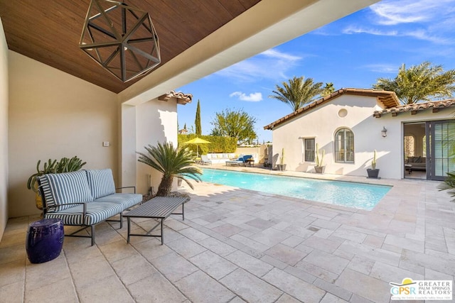 view of swimming pool with an outdoor living space and a patio area