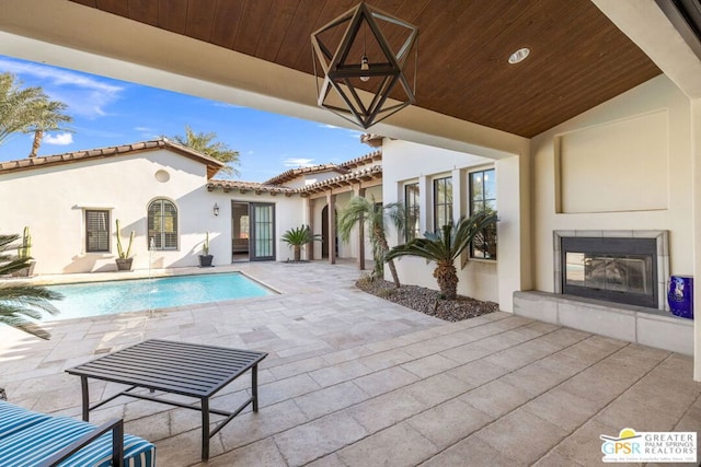 view of swimming pool with a patio area and a fireplace