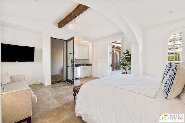 bedroom with beam ceiling, sink, a closet, and ensuite bath