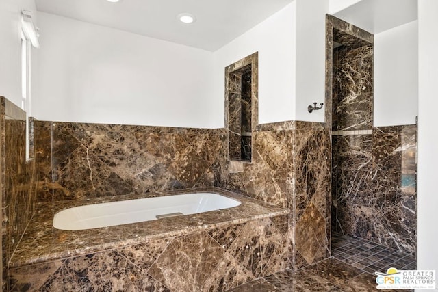 bathroom featuring tiled tub