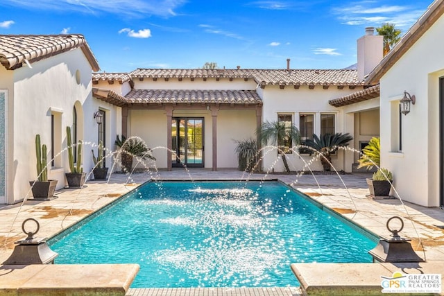 back of house with pool water feature and a patio area