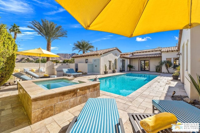 view of pool featuring a patio area and an in ground hot tub