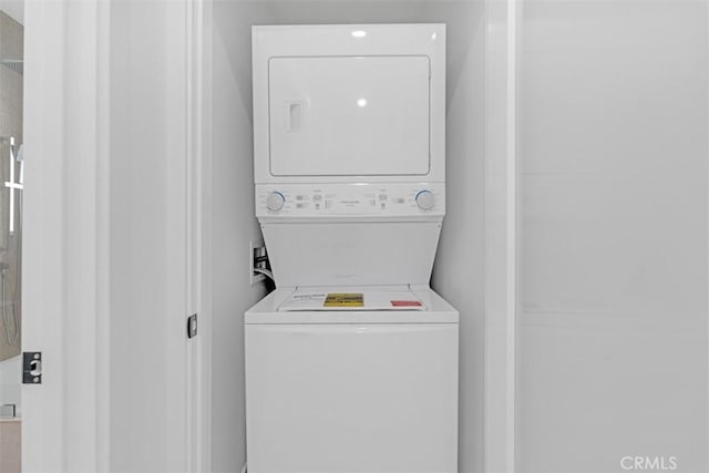 clothes washing area featuring stacked washer / dryer