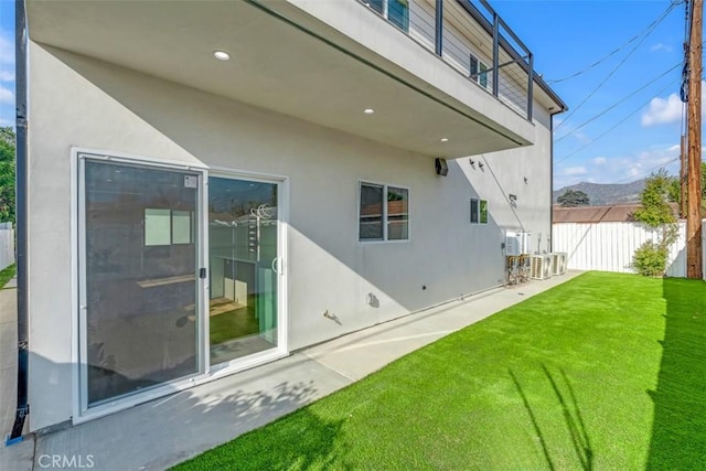 back of property with a yard and a patio