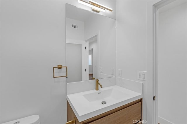 bathroom featuring toilet and vanity