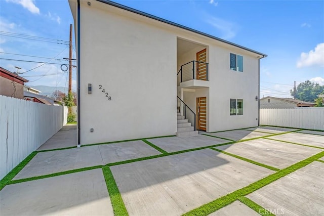 back of house featuring a balcony and a patio