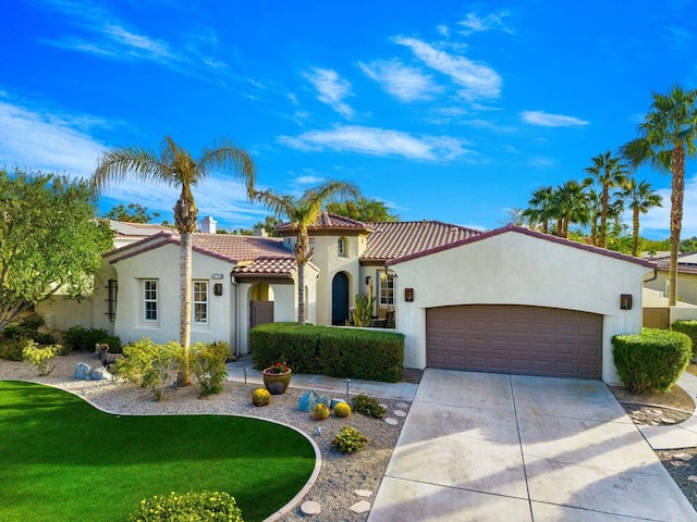 mediterranean / spanish-style house with a garage and a front lawn