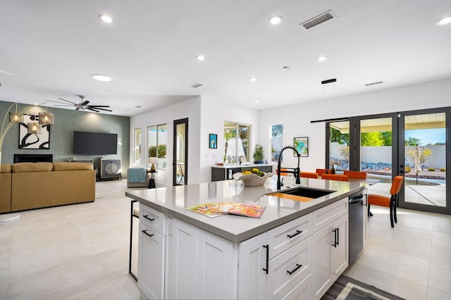 kitchen featuring white cabinetry, sink, a center island with sink, and ceiling fan