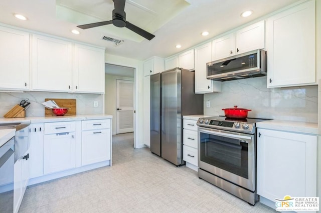 kitchen featuring decorative backsplash, white cabinetry, appliances with stainless steel finishes, and ceiling fan