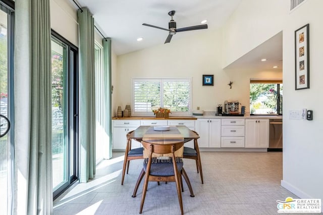 dining space with ceiling fan, light tile patterned floors, vaulted ceiling, and plenty of natural light