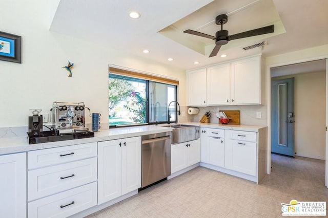 kitchen with white cabinetry, ceiling fan, a tray ceiling, dishwasher, and sink