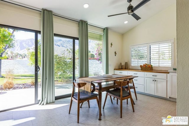 tiled dining area featuring a mountain view, ceiling fan, and vaulted ceiling