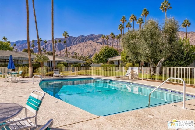 view of pool with a mountain view and a patio