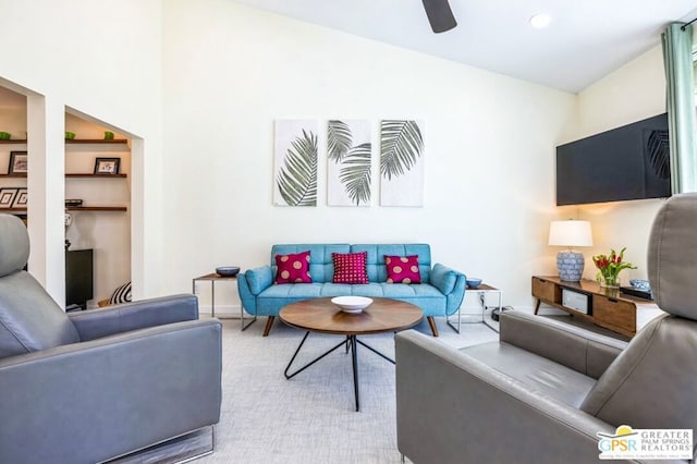 living room featuring ceiling fan and built in shelves