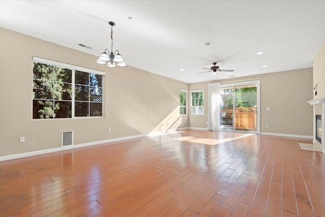 unfurnished living room with light wood-type flooring and ceiling fan with notable chandelier