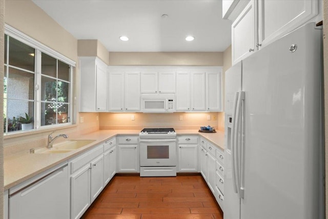 kitchen featuring white appliances, light hardwood / wood-style flooring, white cabinetry, and sink