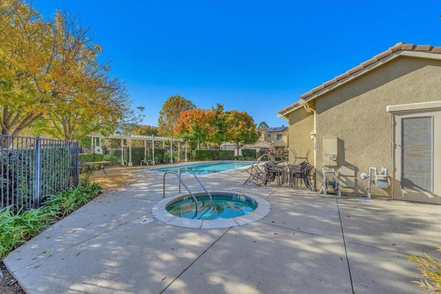 view of swimming pool with a hot tub