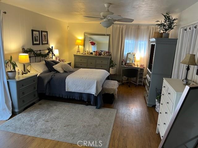 bedroom with ceiling fan and dark hardwood / wood-style flooring