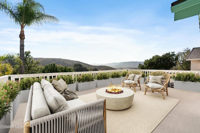 view of patio / terrace with a mountain view and an outdoor fire pit