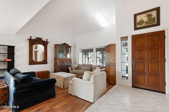 living room with high vaulted ceiling and light wood-type flooring