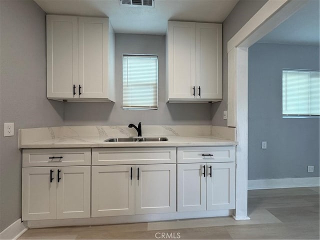 kitchen featuring white cabinetry, a healthy amount of sunlight, and sink