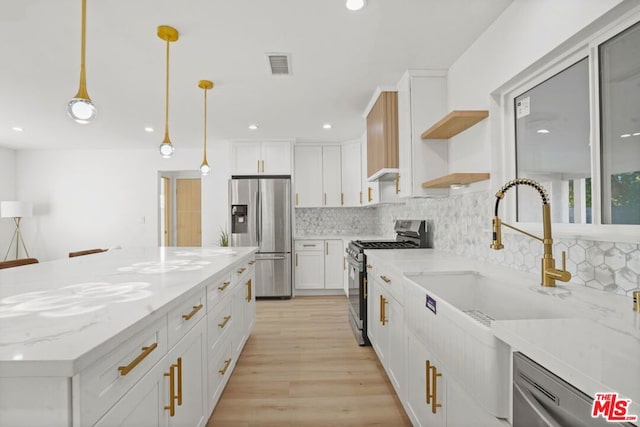 kitchen with pendant lighting, white cabinetry, decorative backsplash, and stainless steel appliances