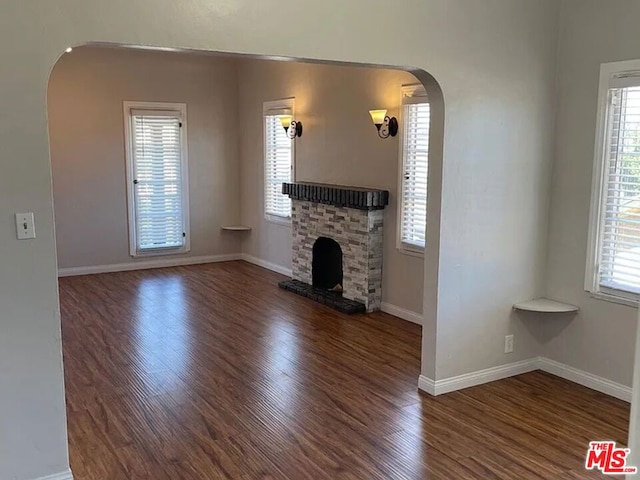 unfurnished living room featuring dark hardwood / wood-style flooring and a fireplace