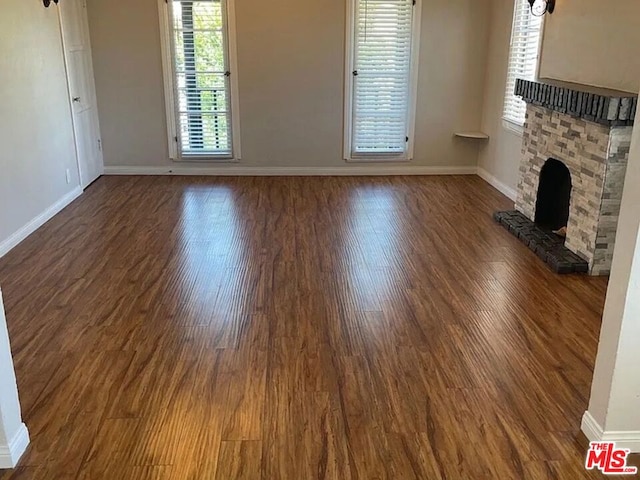 unfurnished living room with a fireplace and dark hardwood / wood-style flooring