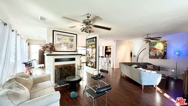 living room featuring ceiling fan and dark hardwood / wood-style floors