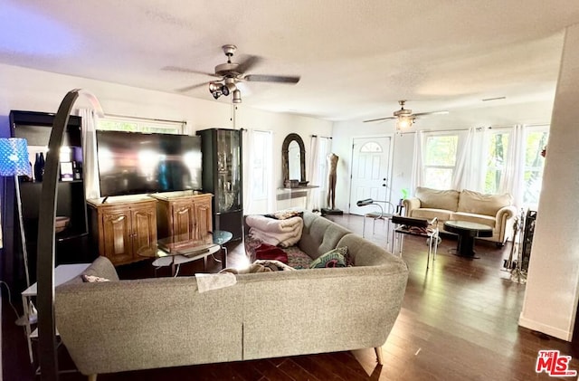 living room featuring ceiling fan and dark wood-type flooring