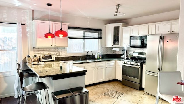 kitchen featuring decorative light fixtures, white cabinetry, stainless steel appliances, and sink