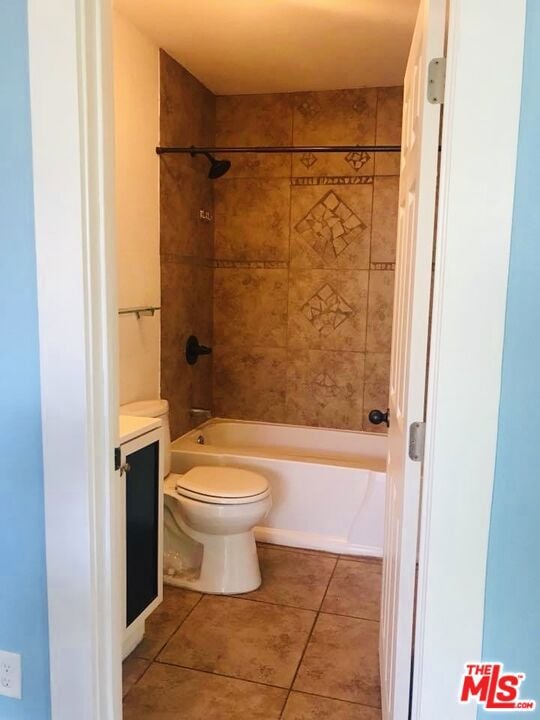 full bathroom with tile patterned flooring, vanity, tiled shower / bath combo, and toilet