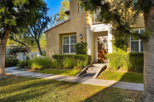 view of exterior entry with a lawn