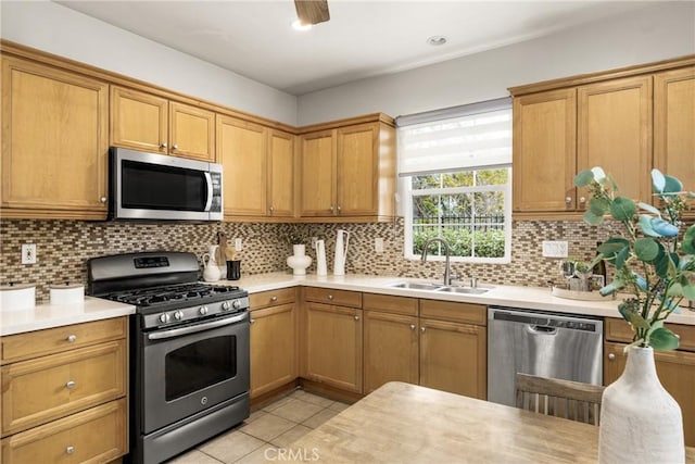 kitchen featuring light tile patterned floors, sink, appliances with stainless steel finishes, and tasteful backsplash