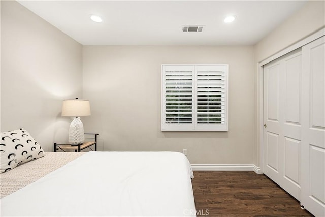 bedroom featuring dark wood-type flooring and a closet