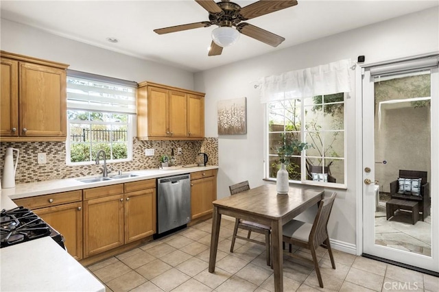 kitchen featuring a wealth of natural light, light tile patterned floors, dishwasher, and sink