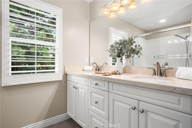 bathroom featuring a shower with shower door, a wealth of natural light, tile patterned floors, and vanity