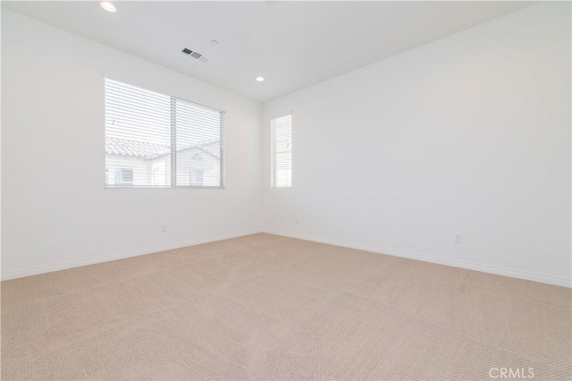 unfurnished room featuring light carpet