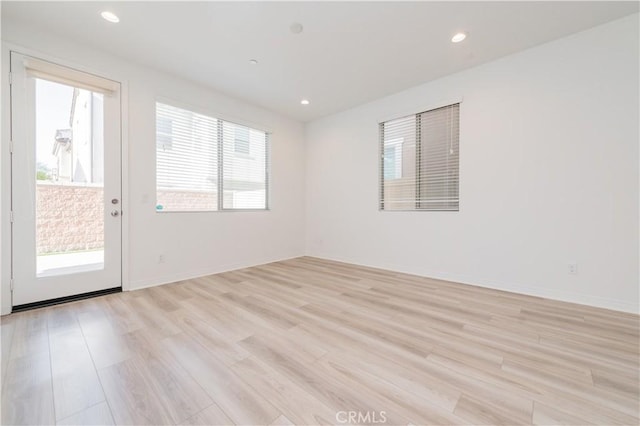 empty room featuring plenty of natural light and light hardwood / wood-style flooring