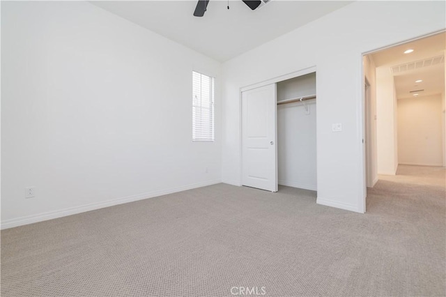 unfurnished bedroom with light carpet, ceiling fan, and a closet