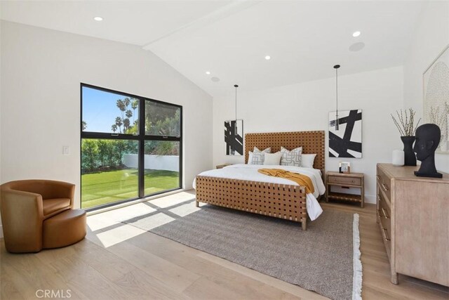 bedroom featuring light wood-type flooring and vaulted ceiling