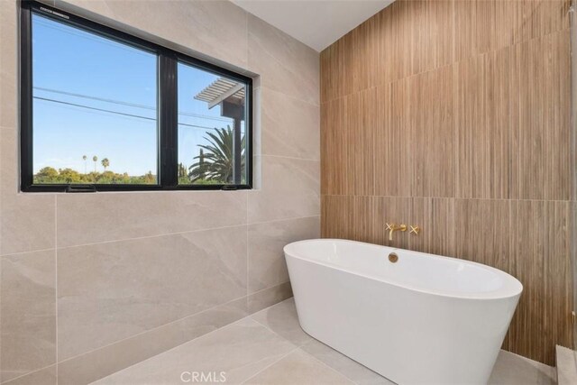 bathroom with tile walls and a bathing tub