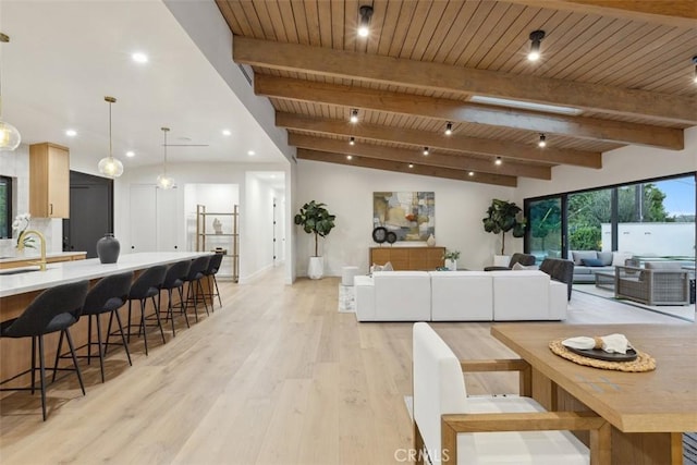 dining space with beamed ceiling, wood ceiling, and light wood-type flooring