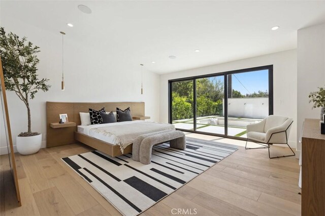 bedroom with access to exterior and light hardwood / wood-style flooring