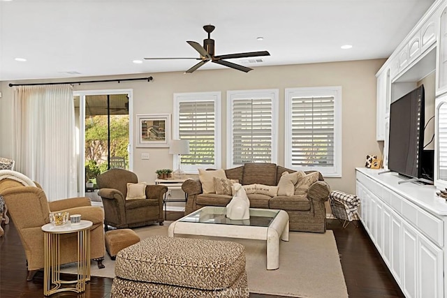 living room featuring ceiling fan and dark hardwood / wood-style flooring