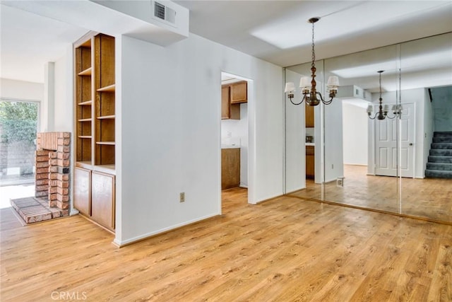 unfurnished dining area featuring light wood-type flooring and a chandelier