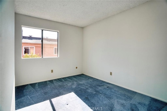 empty room with a textured ceiling and dark colored carpet